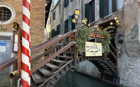 Ponte in legno a Venezia, con insegna "Roste Vecie". Perfetto per un free tour alla scoperta dei vicoli nascosti.