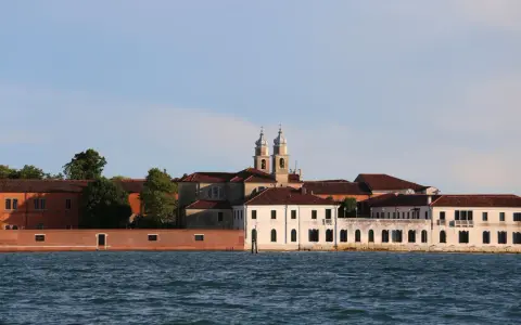 Edifici storici sul canale, tra cui una chiesa con due campanili, che un tempo ospitavano il museo del manicomio di Venezia.