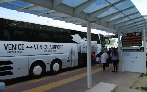 Autobus ATVO Express per l'aeroporto di Venezia. Persone in attesa alla fermata.
