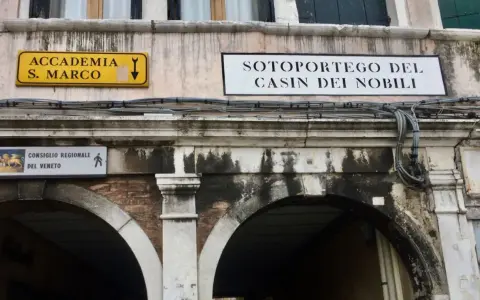 Segnali stradali a Venezia indicano "Accademia S. Marco" e "Sotoportego del Casin dei Nobili".