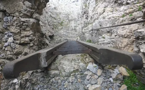 Scalinata in metallo e legno su roccia, parte di un percorso attrezzato, tipico delle ferrate in Veneto.