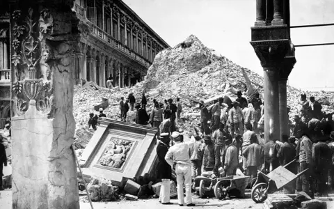 Rovine e folla di curiosi dopo il crollo del campanile di San Marco. Iniziata la ricostruzione.