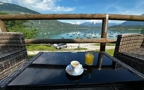 Un caffè e un succo d'arancia con vista sul lago di Santa Croce, ideale per un momento di relax e per decidere dove mangiare.