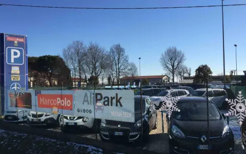 Parcheggio all'aeroporto di Venezia Marco Polo con cartelli informativi e auto in sosta.