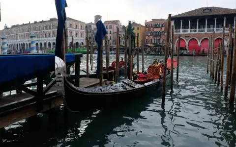 Gondole ormeggiate in un canale veneziano, con palazzi storici sullo sfondo. Immagine che evoca il fascino di quando è stata costruita Venezia.