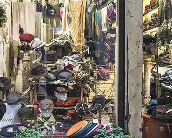 Vetrina di negozi Venezia con cappelli eleganti e sciarpe colorate, un'esplosione di stile per ogni occasione.