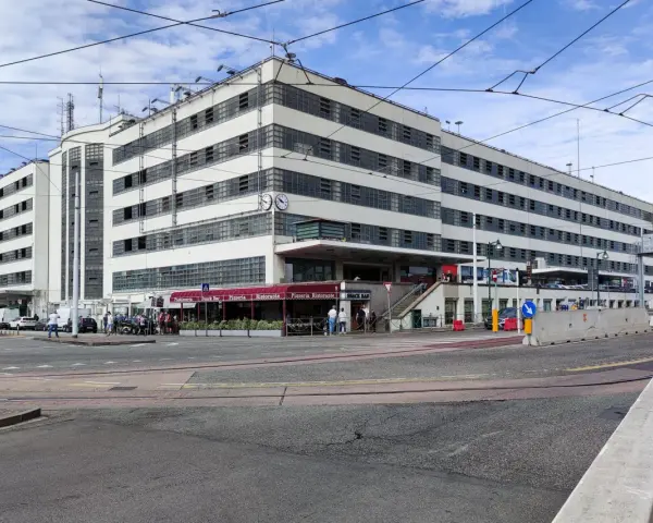 Edificio moderno con finestre a griglia, ideale per chi cerca dove parcheggiare a Venezia. Si intravedono locali commerciali e traffico.