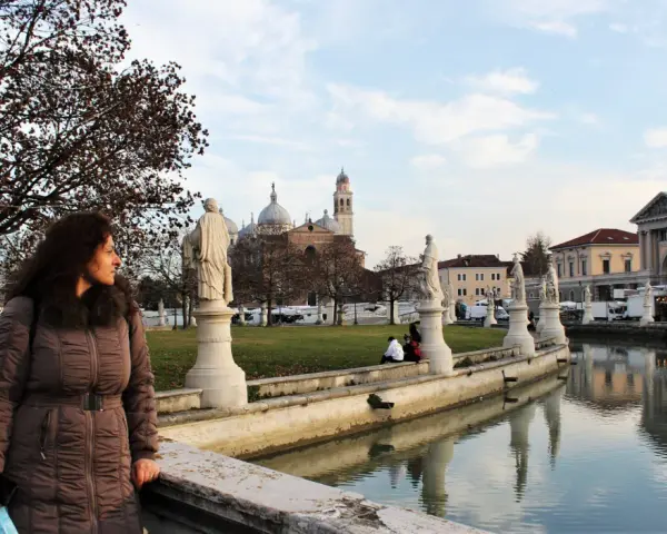 Donna guarda il canale con statue e palazzi a Padova, ideale per visite guidate.