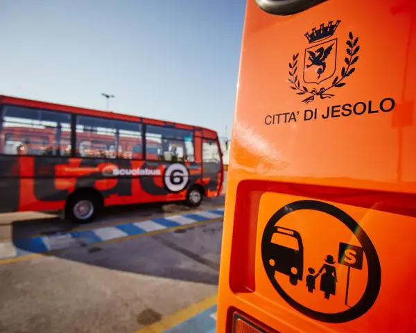 Autostazione Jesolo: scuolabus rosso con stemma "Città di Jesolo" e simbolo di fermata.