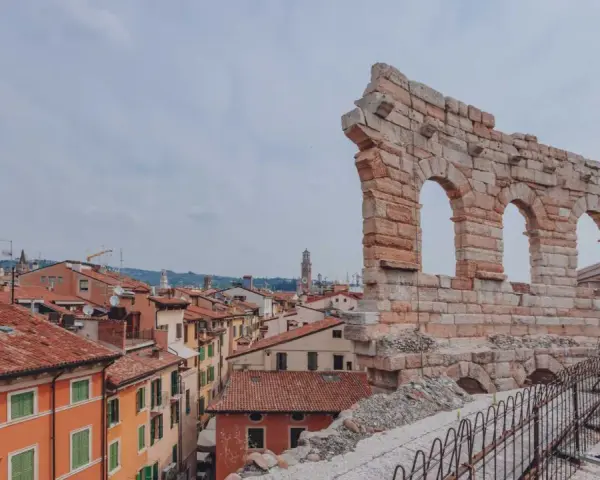 Resti antichi dell'Arena di Verona, testimoni di quanti anni ha l'Arena di Verona, si stagliano su un panorama di tetti rossi.
