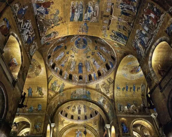 Interno dorato della Basilica di San Marco, con mosaici bizantini che adornano le volte e le cupole di San Marco, raffiguranti scene sacre e figure angeliche.