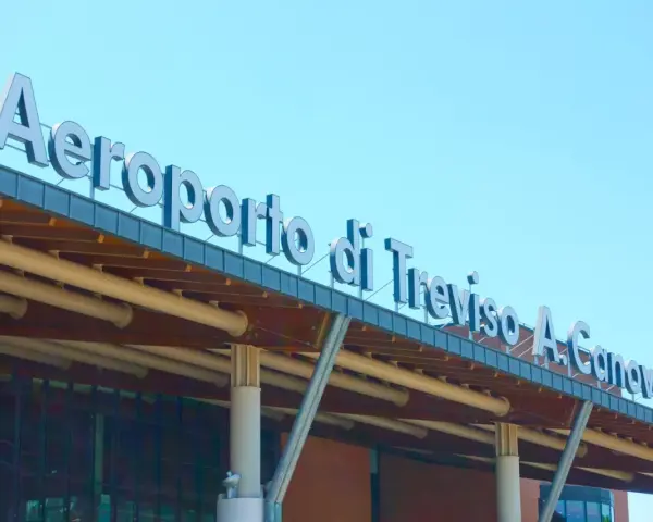 Aeroporto di Treviso A. Canova, uno dei principali aeroporti del Veneto, con insegna luminosa sotto un cielo azzurro.