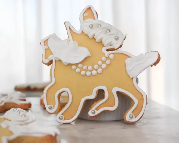 Biscotti a forma di cavallo decorati con glassa bianca e perline argentate, un dolce San Martino che racconta una storia.