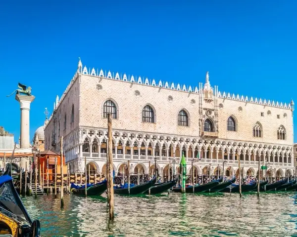 Gondole ormeggiate davanti a Palazzo Ducale, un must per chi cerca cosa vedere a Venezia. Il Leone di San Marco veglia sulla laguna.