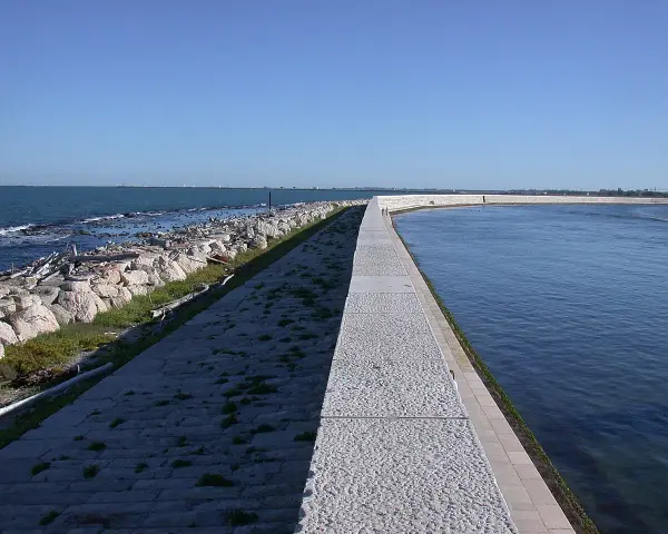 Passeggiata sul molo che porta alla spiaggia Ca' Roman. Come arrivare: segui il sentiero lastricato lungo il mare.