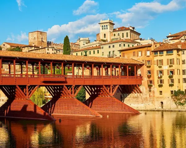 Ponte di Bassano, un'icona di legno rosso sul fiume Brenta. Curiosità: un tempo ospitava botteghe di artigiani.