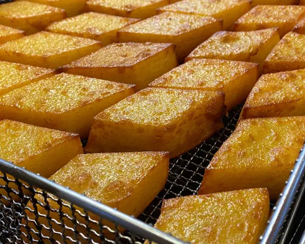 Dorati e croccanti cubetti di crema fritta, un classico di Chioggia, pronti per essere gustati.