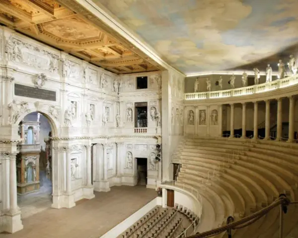 Interno del Teatro Olimpico, gioiello architettonico di una città veneta, con statue, colonne e un soffitto affrescato.