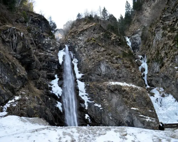 Cascate in Veneto, con rocce innevate e ghiaccio che scende lungo i fianchi della montagna.