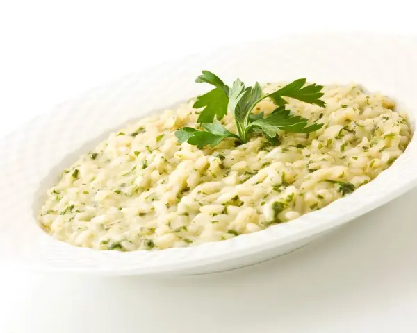 Risotto cremoso con prezzemolo, un piatto che evoca i sapori del mare di Venezia.