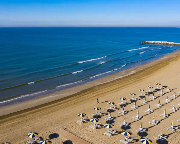 Spiaggia di Cavallino-Treporti con ombrelloni e lettini pronti per l'estate. Scopri come arrivare in questo paradiso!