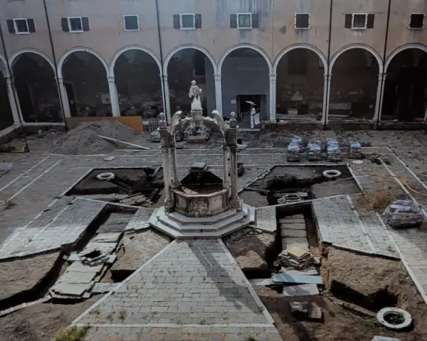 Cortile di Venezia con pozzi in fase di scavo. Archeologia in corso, tra terra e antiche pietre.