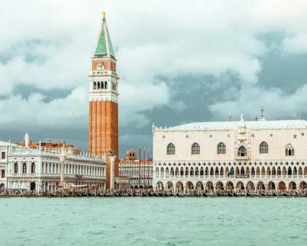 Venezia: Palazzo Ducale, Campanile e il ponte dei sospiri prigione, con gondole sull'acqua.