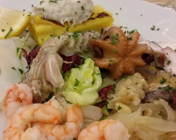 Assaggio di mare con gamberi, polpo e pesce, perfetto per chi cerca ristoranti pesce Caorle. Un piatto colorato e gustoso.