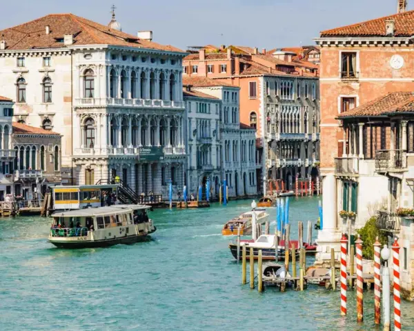 Vaporetti sul Canal Grande, un modo efficiente per il pagamento dei trasporti a Venezia. Palazzi storici e acqua turchese.