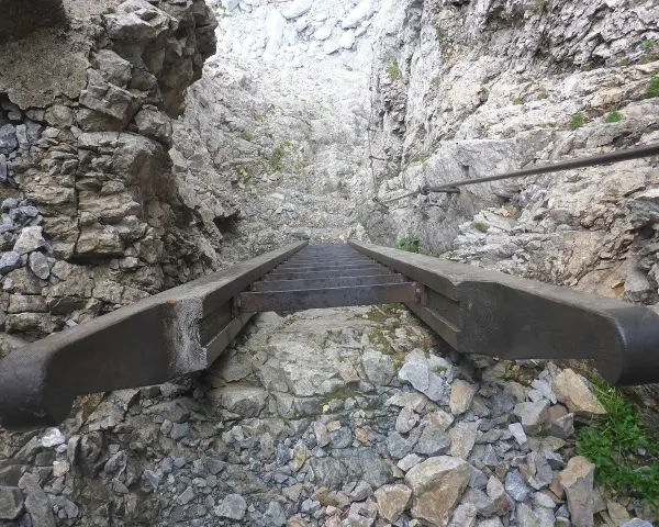 Scalinata in metallo e legno su roccia, parte di un percorso attrezzato, tipico delle ferrate in Veneto.