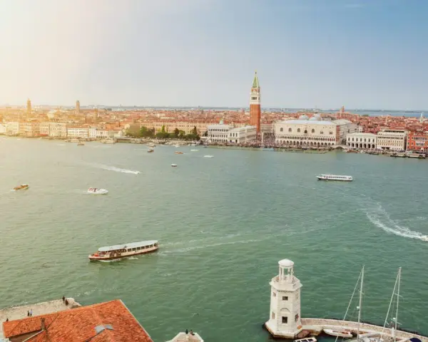 Vista aerea di Venezia con il Canal Grande, imbarcazioni e la famosa arte della città sullo sfondo.