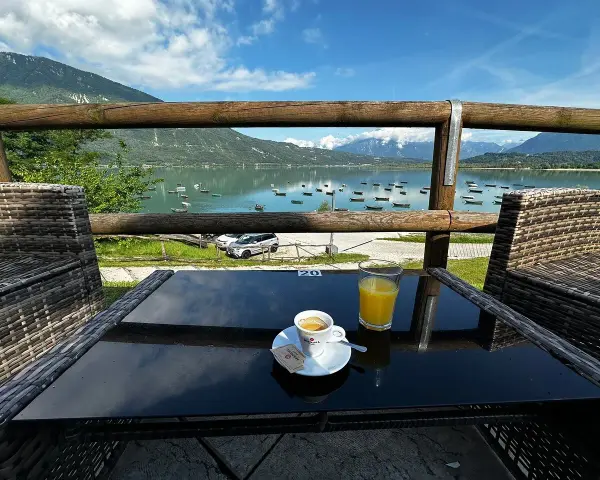 Un caffè e un succo d'arancia con vista sul lago di Santa Croce, ideale per un momento di relax e per decidere dove mangiare.