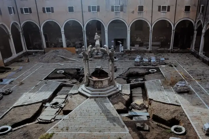 Cortile di Venezia con pozzi in fase di scavo. Archeologia in corso, tra terra e antiche pietre.