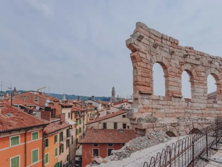 Resti antichi dell'Arena di Verona, testimoni di quanti anni ha l'Arena di Verona, si stagliano su un panorama di tetti rossi.