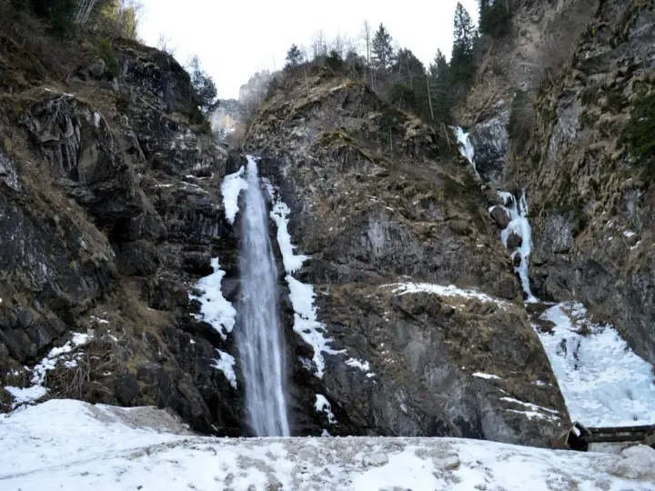 Cascate in Veneto, con rocce innevate e ghiaccio che scende lungo i fianchi della montagna.