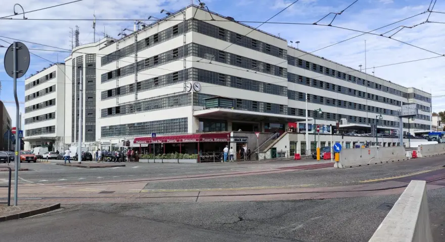 Edificio moderno con finestre a griglia, ideale per chi cerca dove parcheggiare a Venezia. Si intravedono locali commerciali e traffico.