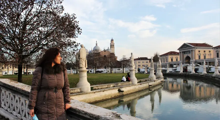 Donna guarda il canale con statue e palazzi a Padova, ideale per visite guidate.