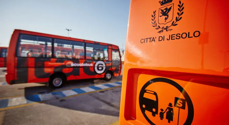 Autostazione Jesolo: scuolabus rosso con stemma "Città di Jesolo" e simbolo di fermata.