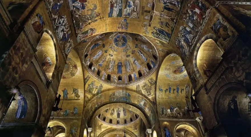 Interno dorato della Basilica di San Marco, con mosaici bizantini che adornano le volte e le cupole di San Marco, raffiguranti scene sacre e figure angeliche.