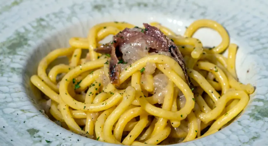 Spaghetti con acciughe e prezzemolo, un assaggio di cosa si mangia a Venezia. Un piatto semplice ma gustoso, perfetto per un pranzo veloce.