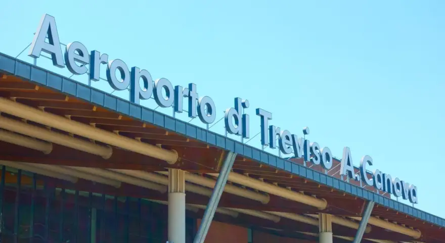 Aeroporto di Treviso A. Canova, uno dei principali aeroporti del Veneto, con insegna luminosa sotto un cielo azzurro.