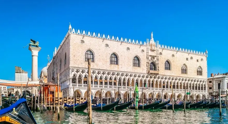 Gondole ormeggiate davanti a Palazzo Ducale, un must per chi cerca cosa vedere a Venezia. Il Leone di San Marco veglia sulla laguna.