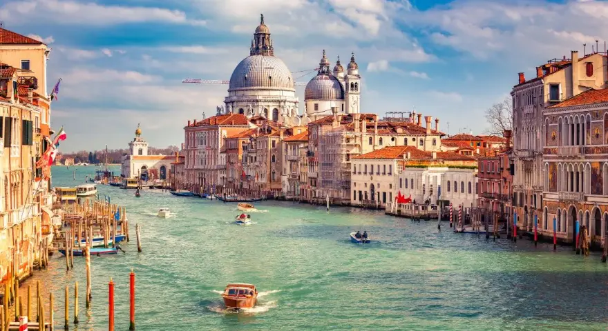 Canale di Venezia, con gondole e vaporetti, sotto il cielo azzurro. Un ricordo della gloriosa repubblica marinara Venezia.