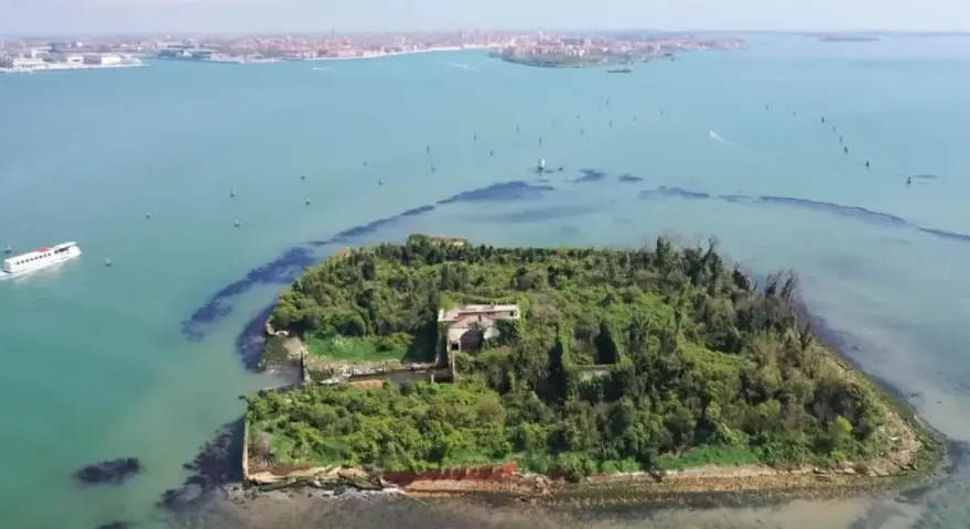 Un'isola verdeggiante con ruderi antichi, circondata da acque azzurre. Venezia è un'isola, e questa vista aerea ne mostra la bellezza selvaggia.