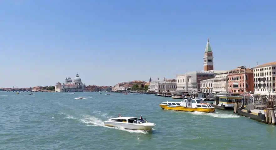 Venezia: il Canal Grande con la linea 1 vaporetto venezia fermate, barche e palazzi storici sotto un cielo azzurro.