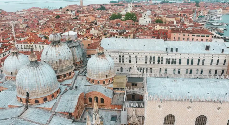 Vista aerea di Venezia con cupole imponenti e tetti rossi, un panorama mozzafiato della città sull'acqua.