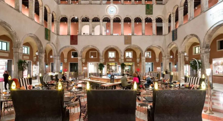 Lussuoso cortile interno con arcate, ideale per scoprire dove fare shopping a Venezia, tra negozi eleganti e aree lounge.