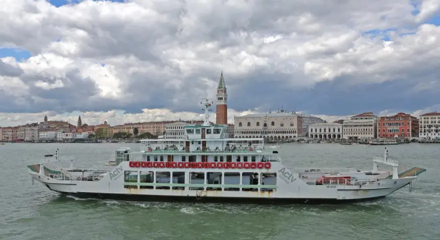Traghetto ACTV che naviga sul Canal Grande, con lo sfondo di Venezia e il Palazzo Ducale.