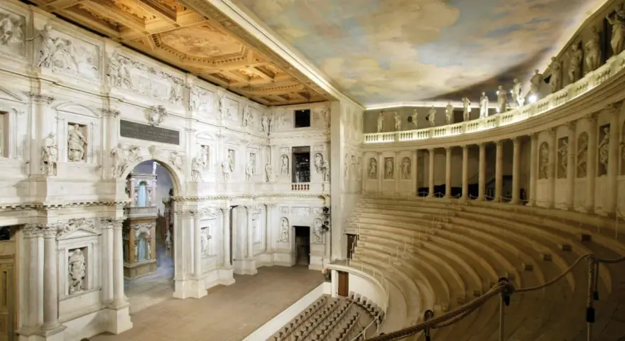 Interno del Teatro Olimpico, gioiello architettonico di una città veneta, con statue, colonne e un soffitto affrescato.