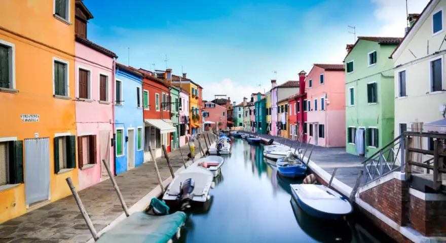 Case colorate lungo un canale a Burano, dove le case sono costruite su palafitte, un'ingegnosa soluzione per capire su cosa è costruita Venezia.